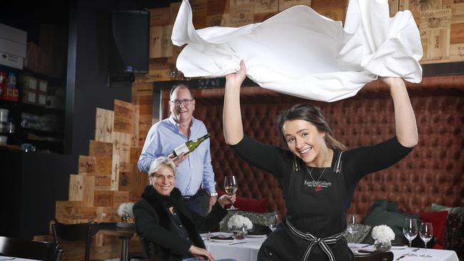 Cara Gordan starts to set up the tables with tablecloths ready for service as Michael Andrewartha and wife Margie Andrewartha celebrate the chance to get back to business soon at East End Cellars. Picture: Sarah Reed