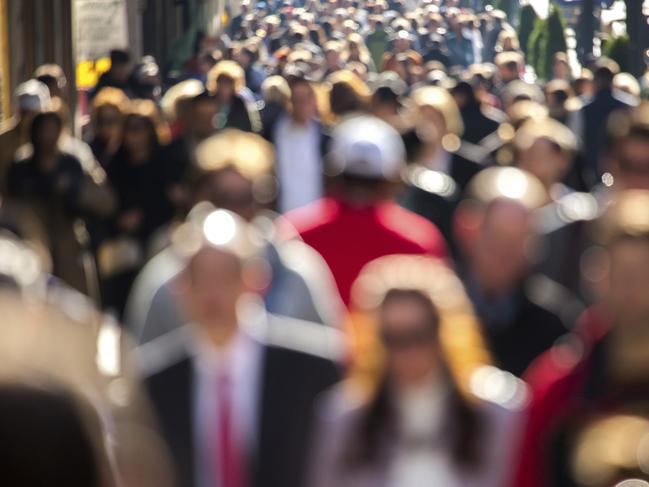 Anonymous crowd of people walking street