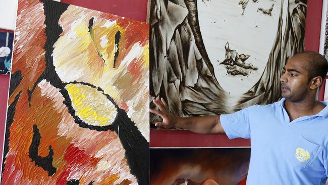 Myuran Sukumaran shows his new painting from his works in the art workshop at Kerobokan Jail, in Bali, in 2010. Picture: HWT library