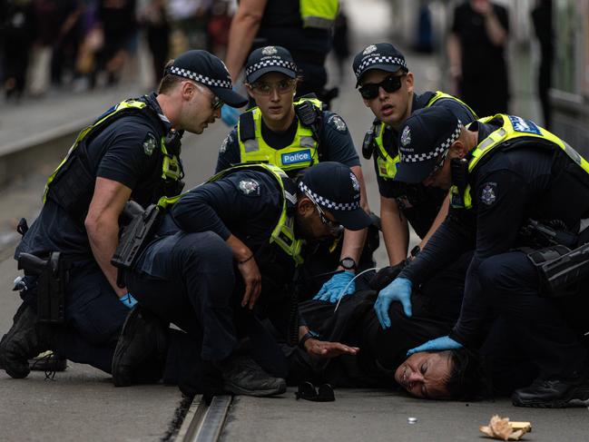 Members of Victoria Police arrest an pro-trans activist following scuffles. Picture: NewsWire / Diego Fedele