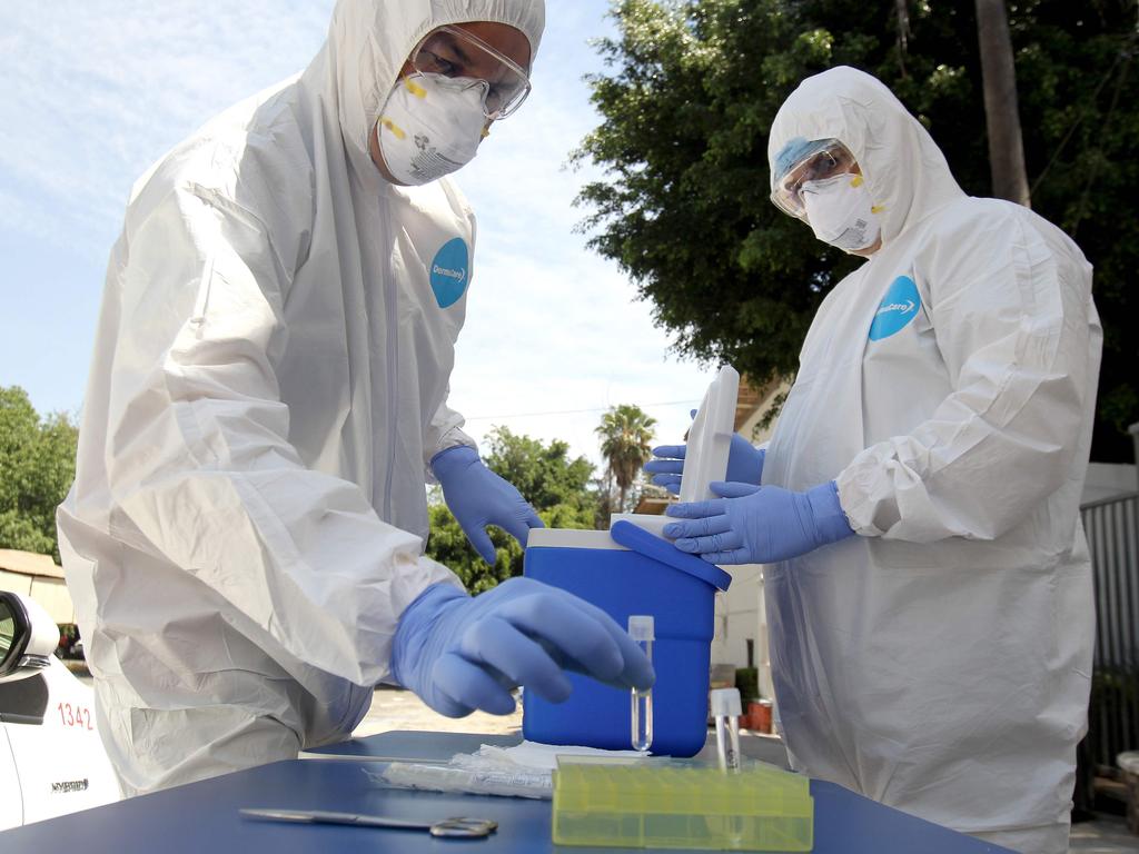 Health workers wearing protective suits, prepare to take a CPR test on drivers showing suspected symptoms of COVID-19, in Guadalajara, Mexico. Picture: Ulises Ruiz/AFP.