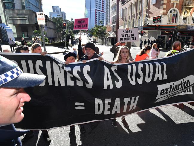 Extinction Rebellion protestors are seen blocking peak hour traffic at the corner of Turbot and George Streets in Brisbane, Monday, July 15, 2019.