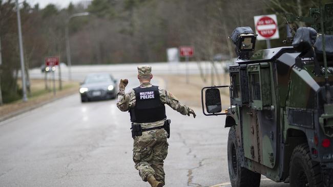 A member of the Rhode Island National Guard Military Police directs a motorist with New York license plates at a checkpoint on I-95 near the border with Connecticut where New Yorkers must pull over and provide contact information and are told to self-quarantine for two weeks.