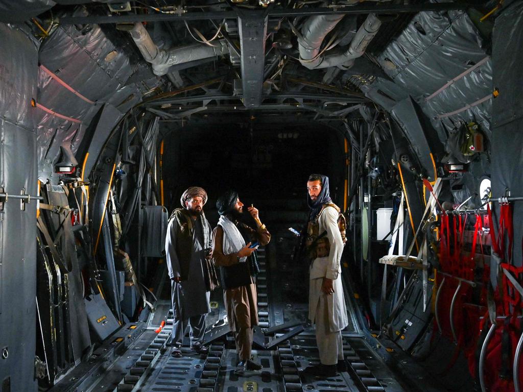 Taliban fighters stand inside an Afghan Air Force aircraft at the airport in Kabul. Picture: Wakil KOHSAR / AFP