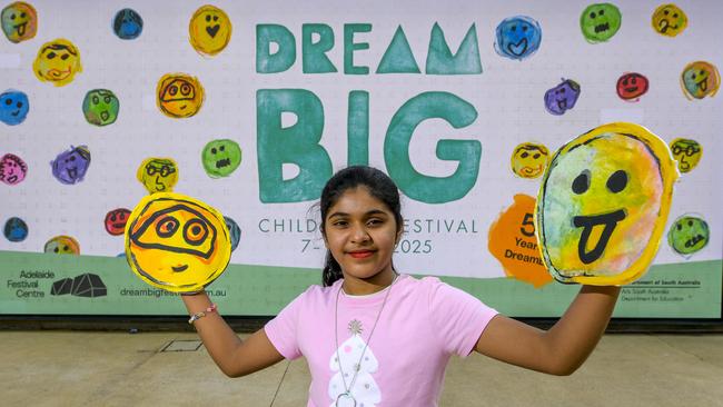 DreamBig Children's Festival 2025 poster competition winner Fidak with background screen of her winning design. Picture: RoyVPhotography.