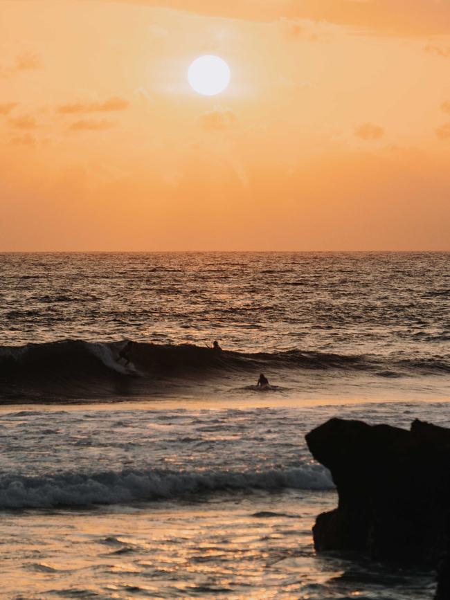 Surfers catch their final waves.