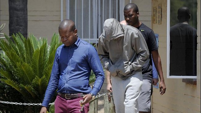 South Africa's Olympic sprinter Oscar Pistorius (C) leaves the Boshkop police station on February 14, 2013 in Pretoria East, to be taken into police custody after allegedly shooting dead his model girlfriend having mistaken her for an intruder at his upscale home.   AFP PHOTO