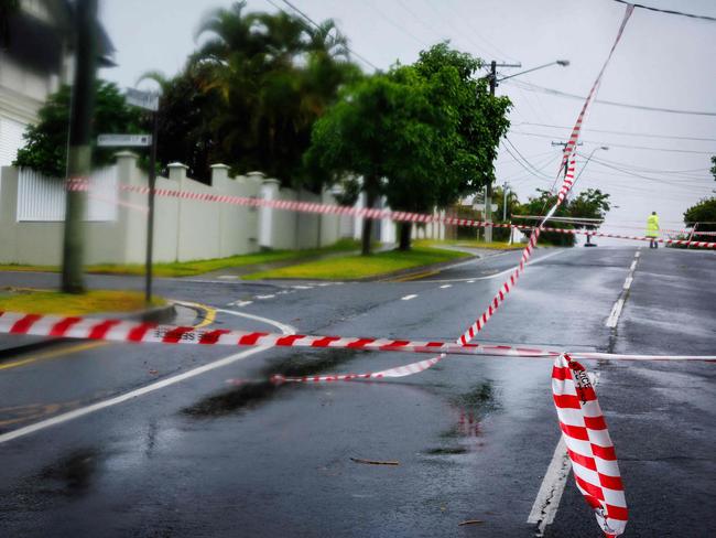 Police cordons stop traffic after power lines fell across a road in Brisbane. Picture: Patrick Hamilton/AFP