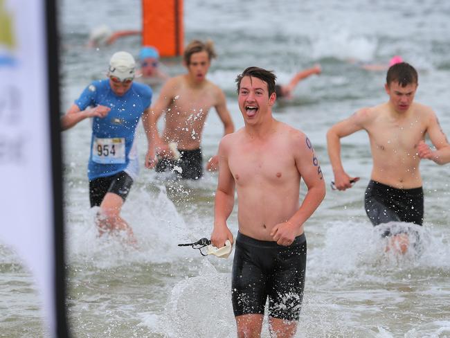 Will Caglayan, from New Town High School, all smiles after finishing his swim leg in the grade 8 boys individual section.