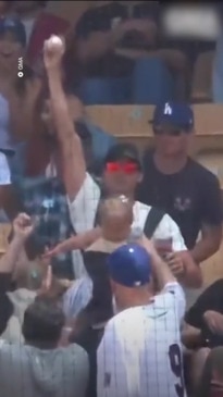 Dodgers fan catches home run with her hat while holding a beer in