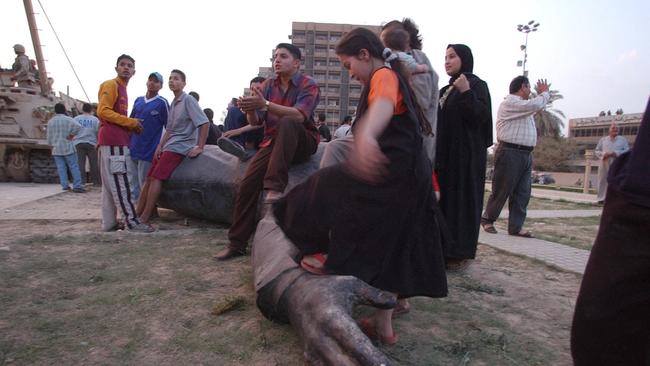 Baghdadis celebrate the toppling of a statue of Saddam Hussein on Firdos Square in April 2003. Picture John Feder