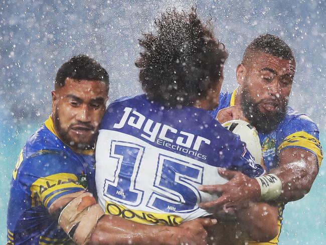 Canterbury's Raymond Faitala-Mariner cops a big tackle in heavy rain during NRL match Parramatta Eels v Canterbury Bulldogs at ANZ Stadium. Picture. Phil Hillyard