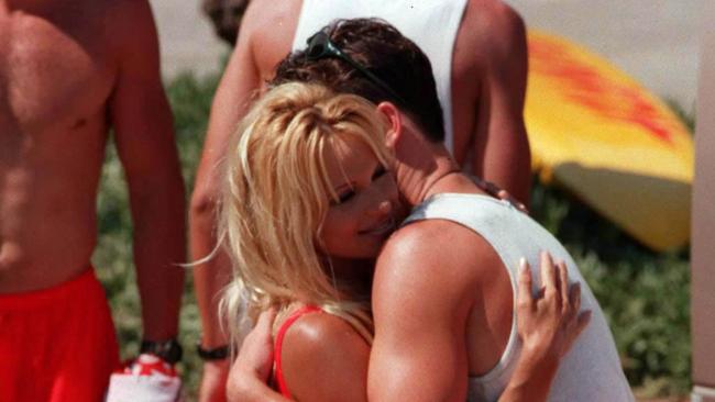 Ironman Jonathon Crowe hugs actor Pamela Anderson during filming of the TV show Baywatch in 1996