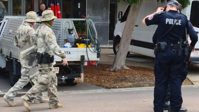 TRG officers and NT police officers at the scene of the siege in Wood St in the CBD. Picture: Thomas Morgan