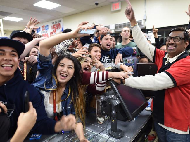 Winner ... 7-Eleven store clerk M. Faroqui celebrates with customers after learning the store sold a winning Powerball ticket. Picture: AP