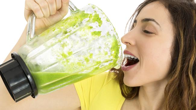 woman guzzling green smoothie generic image