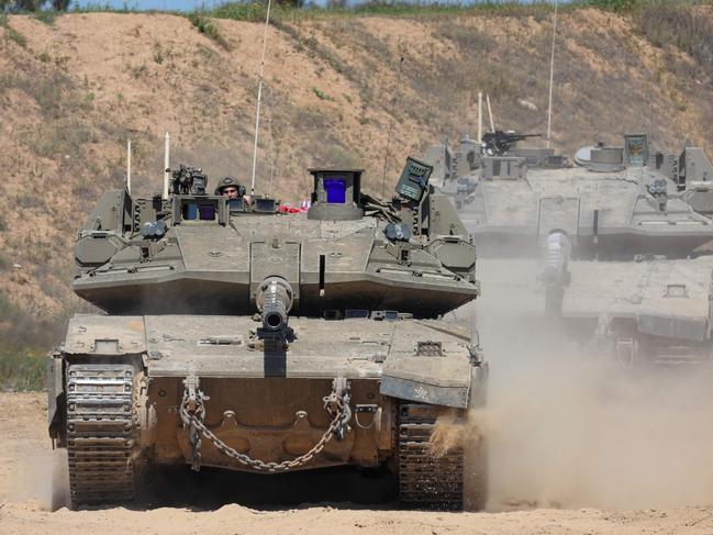 TOPSHOT - An Israeli soldier operates a tank at a position along Israel's southern border with the northern Gaza Strip on March 19, 2025. Israel on March 18 launched its most intense strikes on the Gaza Strip since a January 19 ceasefire with Palestinian militant group Hamas ended more than 15 months of war. (Photo by Jack GUEZ / AFP)