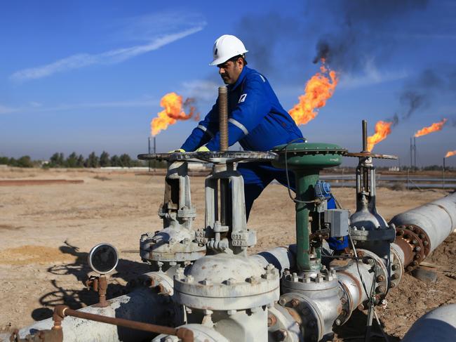 FILE - In this Thursday, Jan. 12, 2017 file photo, a worker operates valves in Nihran Bin Omar field north of Basra, Iraq. An Iraqi oil official says employees of energy giant Exxon Mobil have started evacuating an oil field in the southern province of Basra, amid rising tensions between the United States and Iran. The first group left two days ago and another batch left early Saturday May 18, 2019. (AP Photo/Nabil al-Jurani, File)