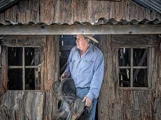 Bruce Green with his saddle and an old house prop he's taking up to the Brisbane Ekka as part of their show entertainment. Picture: Adam Hourigan