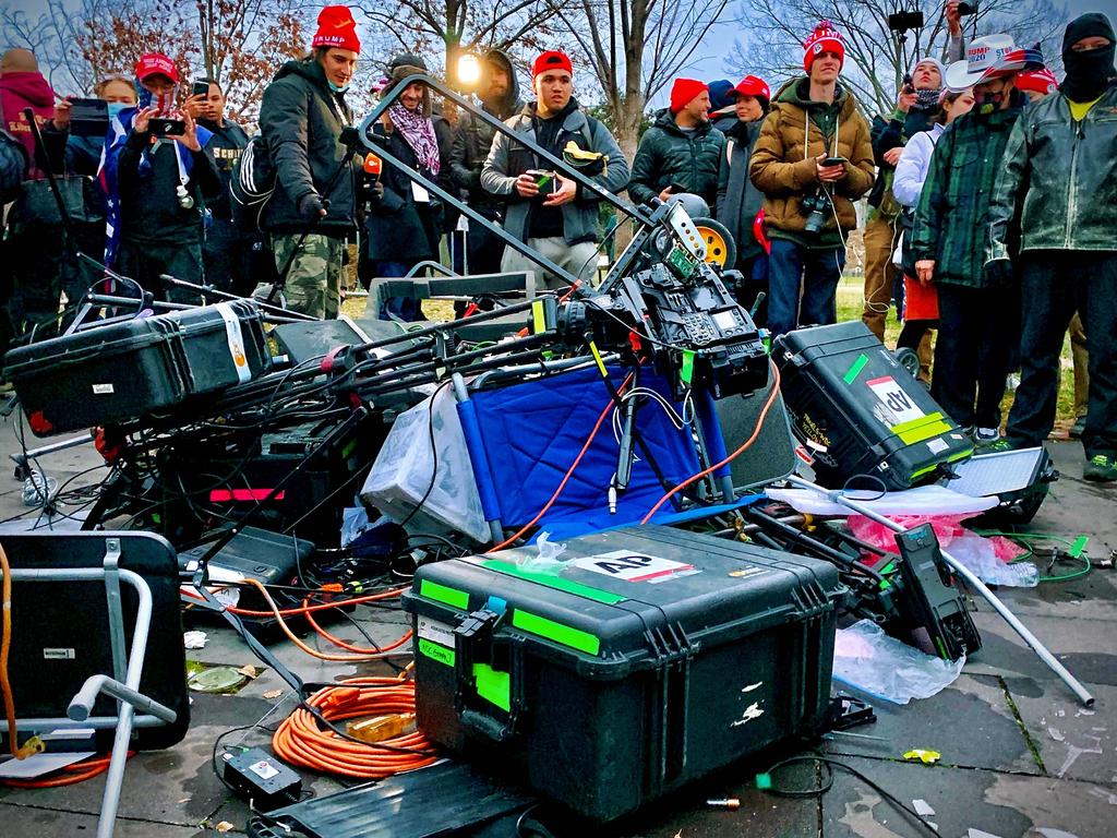 Pro-Trump rioters pictured near destroyed media equipment destroyed during the Capitol riots. Picture: AFP