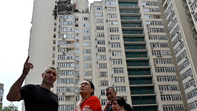 Kyiv's Mayor Vitali Klitschko talks with local residents next to a 24-story building partially destroyed following a Russian missiles strike in Kyiv. Picture: AFP