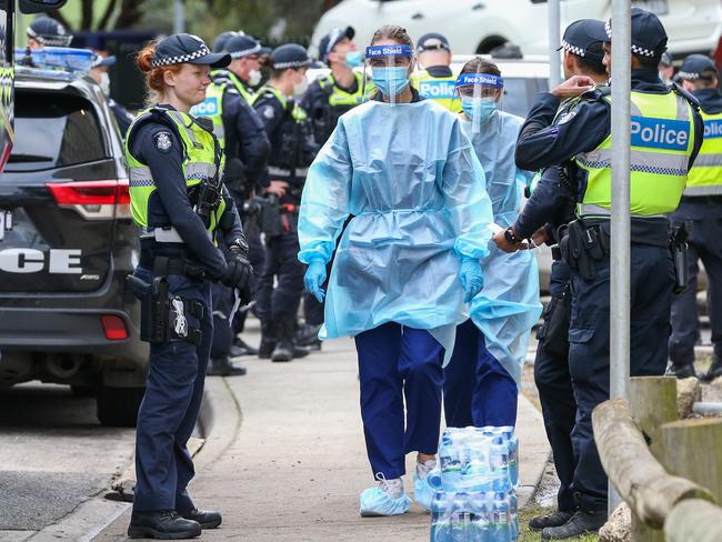 Medical staff wearing personal protective equipment enter the Flemington Public housing flats on Sunday. Picture: Getty Images