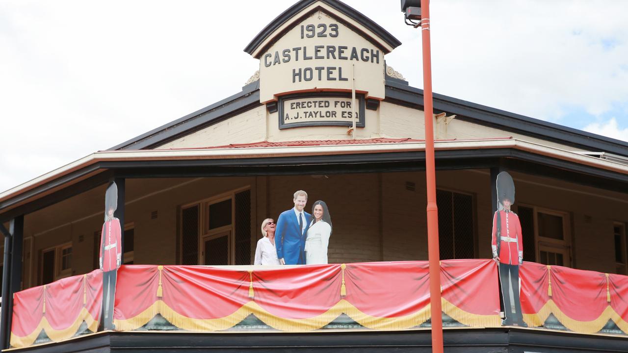 A woman stands next to a cardboard cut out of the royal couple on the balcony of the Castlereagh Hotel. Picture: Toby Zerna