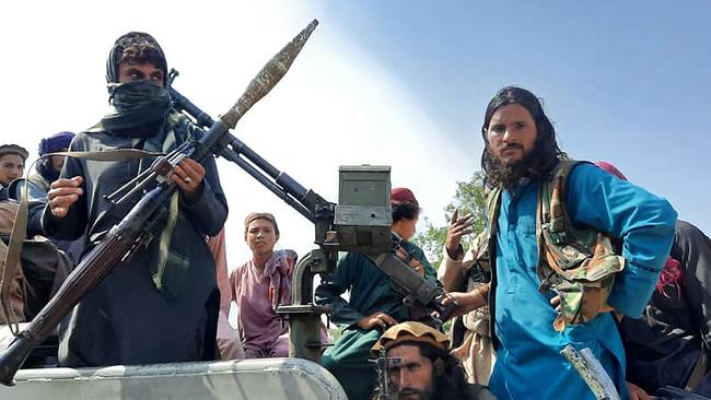 Taliban fighters sit over a vehicle on a street in Laghman province. Picture: AFP