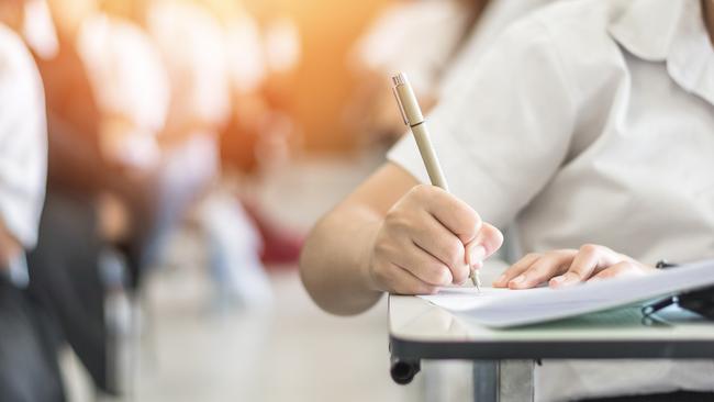 Exam with school student having a educational test, thinking hard, writing answer in classroom for university education admission and world literacy day concept