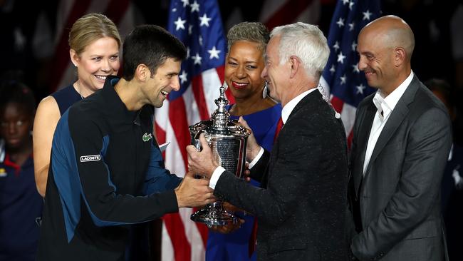 Djokovic is handed the trophy by former champion John McEnroe. Picture: Getty