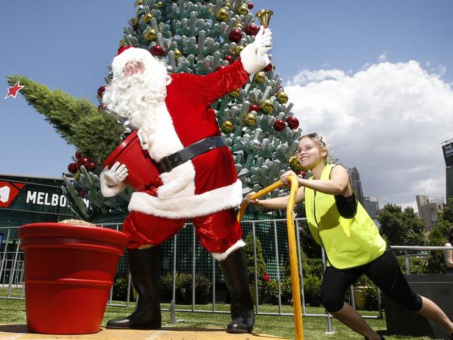 Santa is wheeled in to Federation Square by helper Isabel McCabe. Picture: David Caird