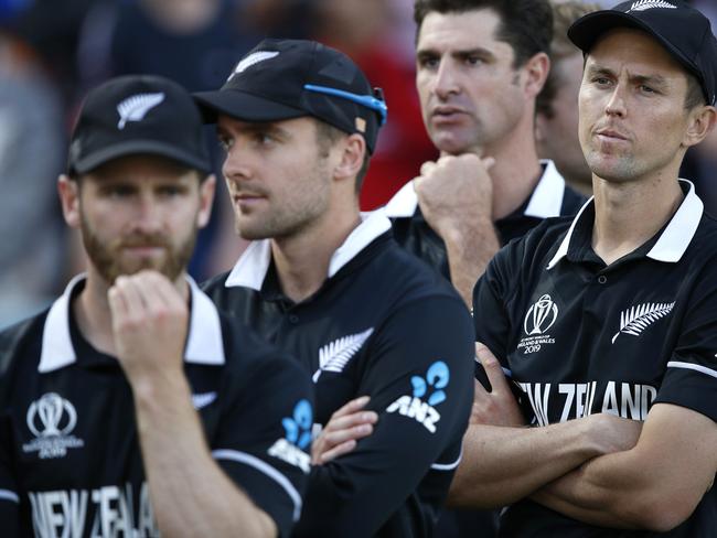 New Zealand's Trent Boult, right, crosses his arms as he waits for the trophy presentation after losing the Cricket World Cup final match between England and New Zealand at Lord's cricket ground in London, Sunday, July 14, 2019. England won after a super over after the scores ended tied after 50 overs each. (AP Photo/Matt Dunham)