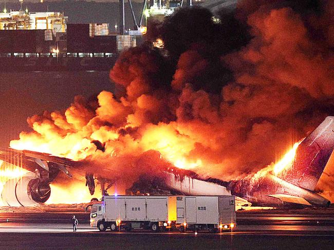 TOPSHOT - This photo provided by Jiji Press shows a Japan Airlines plane on fire on a runway of Tokyo's Haneda Airport on January 2, 2024. A Japan Airlines plane was in flames on the runway of Tokyo's Haneda Airport on January 2 after apparently colliding with a coast guard aircraft, media reports said. (Photo by JIJI PRESS / AFP) / Japan OUT