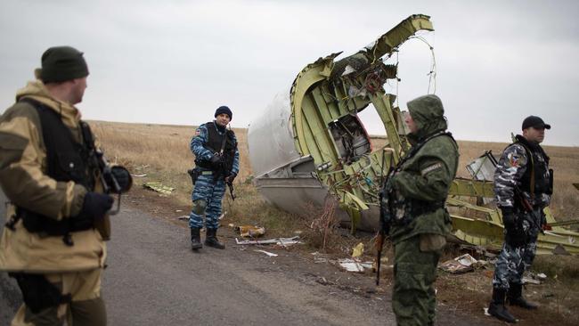 Pro-Russian gunmen watch as Dutch investigators (unseen) arrive near parts of the Malaysia Airlines Flight MH17 at the crash site in eastern Ukraine. Picture: AFP