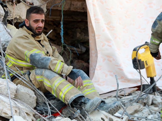 A member of the Lebanese civil defence rests as the search and rescue operations continue in the regime-controlled town of Jableh in the province of Latakia, northwest of the capital Damascus. Picture: AFP