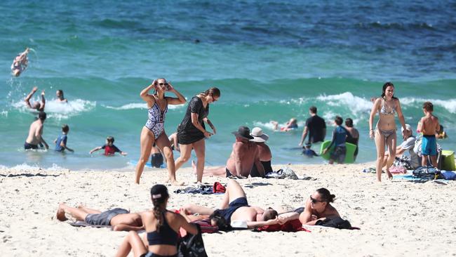 Beachgoers swim, tan and relax on Sunday at Burleigh Beach on the Gold Coast. Picture: Jason O'Brien