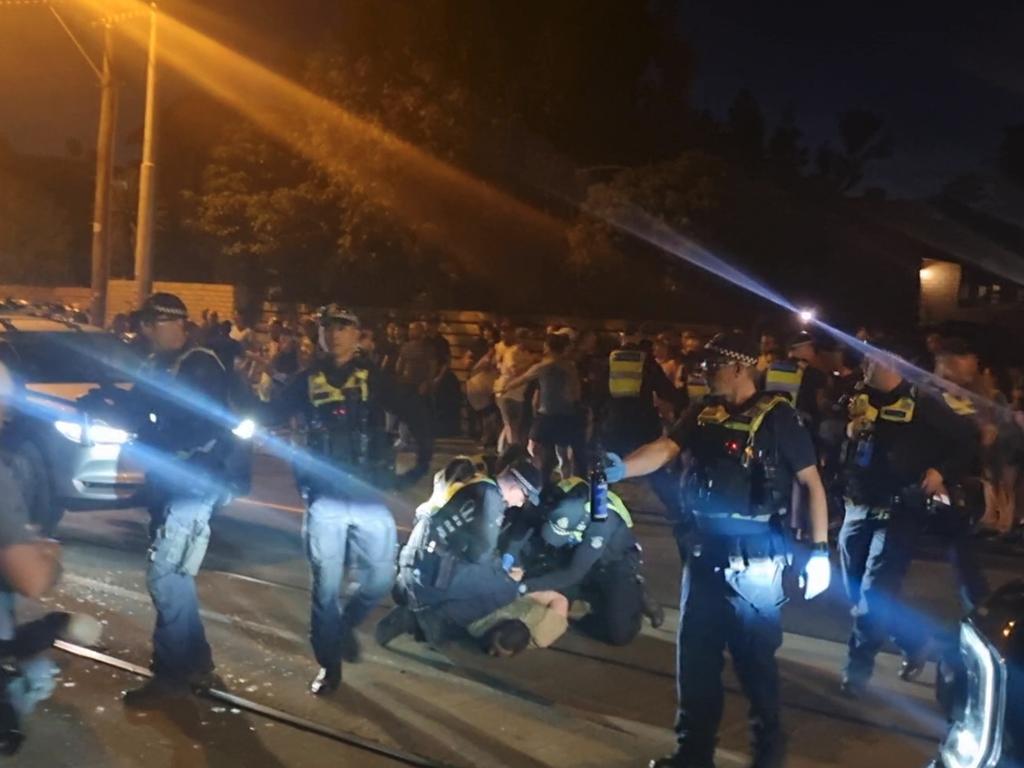 Police pin a protestor to the ground.