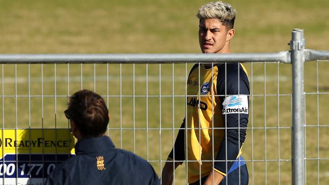 Dylan Brown listens to instructions given from outside the fence by Andrew Johns during a Parramatta Eels training session.