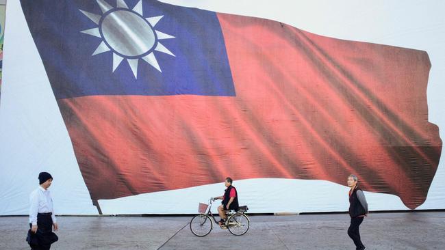 People walk past a Taiwanese flag in New Taipei City on Saturday. Picture: AFP