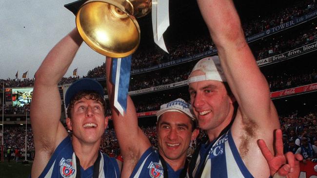 Glenn Freeborn, Wayne Schwass and Corey McKernan hold up their Premiership cup.