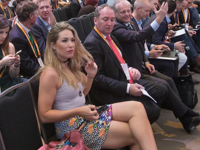 This photo, published by the Daily Telegraph, shows Mr Joyce sneaking a peek at then-media adviser Vikki Campion at a farm summit in Sydney in November 2016.