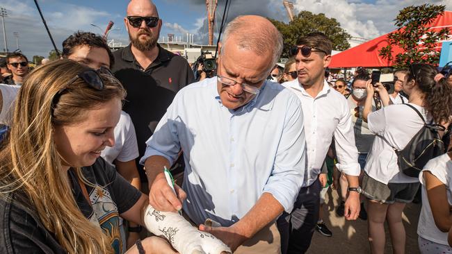 Mr Morrison signs a cast. Picture: Jason Edwards