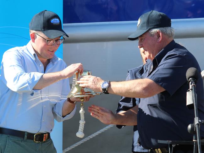 Adam Marshall receives a bell from Yamba Welding and Engineering managing director Bill Collingburn at the launch of the NSW Fisheries boat, Solitary Ranger at Coffs Harbour Marina. Photo: Tim Jarrett