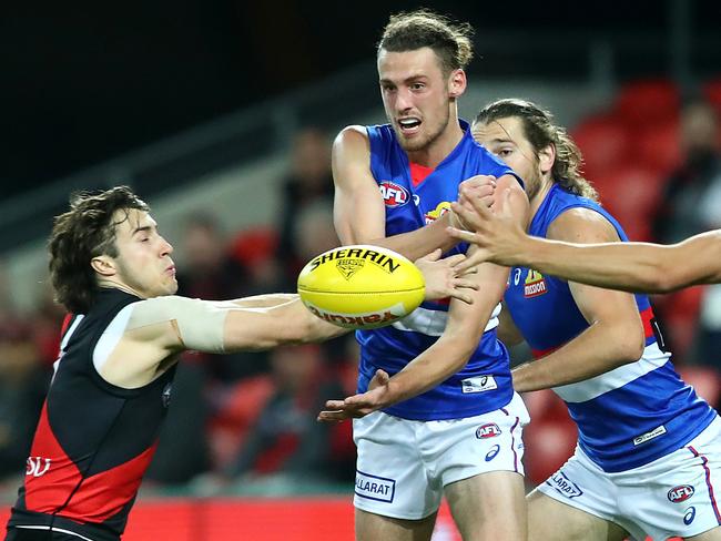 Lachie Young of the Bulldogs gets a handball away against Essendon at Metricon Stadium on the Gold Coast last Friday night. Picture: Jono Searle