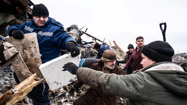 Local residents remove debris of a residential building destroyed by shelling, as Russia's invasion of Ukraine continues, in Zhytomyr