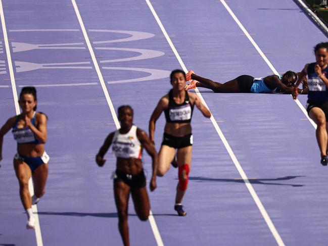 South Sudan's Lucia Moris (2R) falls while competing in the women's 100m heat of the athletics event at the Paris 2024 Olympic Games at Stade de France in Saint-Denis, north of Paris, on August 2, 2024. (Photo by Anne-Christine POUJOULAT / AFP)