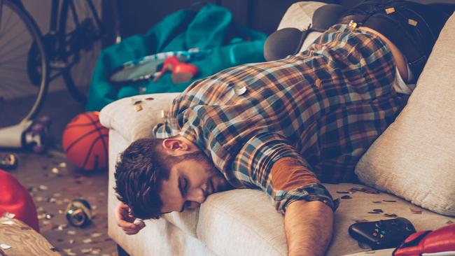 Young handsome man passed out on sofa in messy room after party Aribnb wild parties generic istock photo