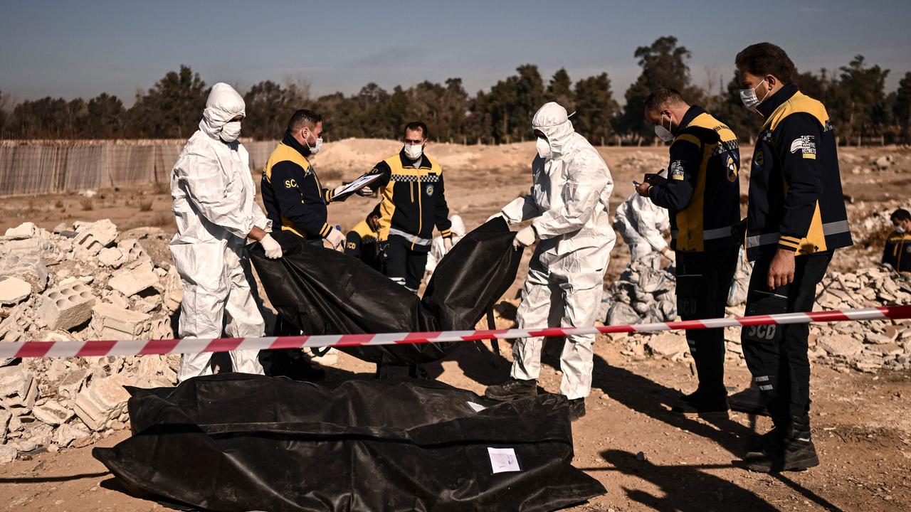 Members of Syria's White Helmets civil defence transport body-bags containing human remains. Picture: Aris Messinis/AFP