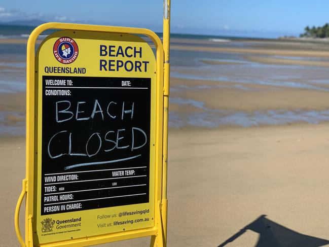 Flowers left at the base of a red flag at Eimeo Beach closed after 14-year-old boy Mark Angelo Ligmayo was stung by a box jellyfish on Saturday, February 26, 2022. He died at Mackay Base Hospital. Picture: Tara Miko