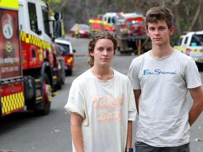 Twins Erica and Peter Campbell-Rogers helped hose down some of the houses under attack from embers from a bush fire near Whitehaven Road in Northmead on Sunday. Picture: Damian Shaw